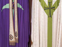Liturgische Gewänder in Violett, Weiß und Grün.