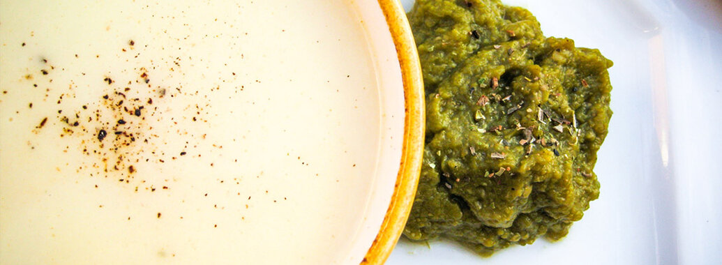 Feine Knoblauchcremesuppe mit einer Prise gemahlenem Pfeffer, sowie kräftig grünes Bohnenpüree mit feinen Kräutern garniert. 