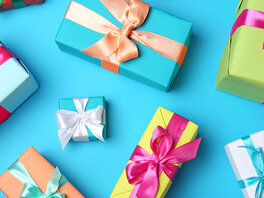 Bunte Geschenkboxen mit Schleifen in unterschiedlichen Größen und Farbkombinationen.