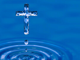 Ein Kreuz geformt aus Wasser schwebend über einer Wasseroberfläche, die durch Tropfen einen Ring aus Wellen bildet.