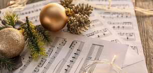 Weihnachtskugeln und Musiknoten auf einem Tisch