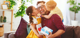 Zwei Kinder beschenken ihren Vater