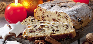 Christstollen mit Rosinen, Zimtsternen und Kerzen