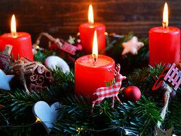 Vier rote brennende Kerzen auf grünem Adventskranz