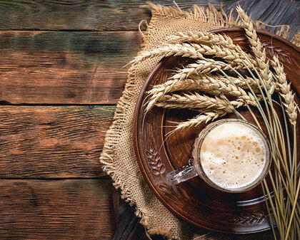 Glas mit dunklem Bier auf einem Holztisch von oben
