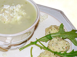 Rucolasuppe mit Krümmeln aus Schafskäse in Schüssel. Dazu serviert Haferklöse. Garniert mit frischem Rucola