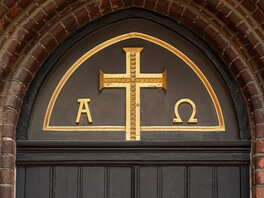 Kircheneingang mit Alpha und Omega