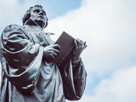 Bronzeskulptur Luthers mit aufgeschlagenem Buch.