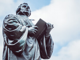Bronzeskulptur Luthers mit aufgeschlagenem Buch.
