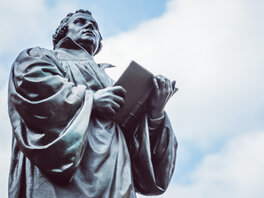 Bronzeskulptur Luthers mit aufgeschlagenem Buch.