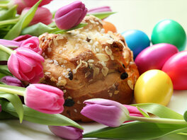 Osterbrot, bunte Eier, pinke Tulpen.