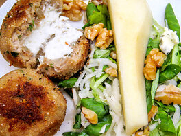 Putenfrikadellen gefüllt mit Frischkäse, neben Birnensalat, mit Walnüssen und Blauschimmelkäsestückchen.