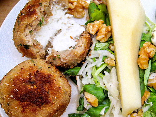 Putenfrikadellen gefüllt mit Frischkäse, neben Birnensalat, mit Walnüssen und Blauschimmelkäsestückchen.