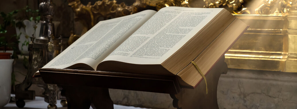 Altar mit einer aufgeschlagenen Bibel, welche auf einem Buchständer liegt. Die Bibel wird von Sonnenstrahlen erleuchtet.