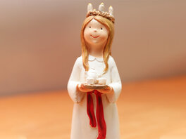 Figur der heiligen Lucia mit einem Kerzenkranz auf dem Kopf