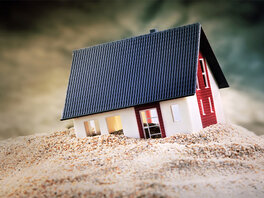Modellhaus versinkt im Sand